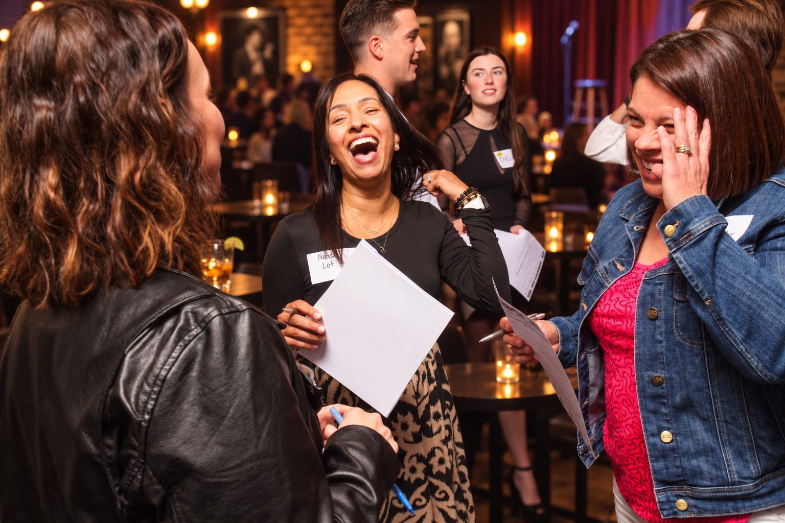 Audience members laugh as they compare their answer sheets